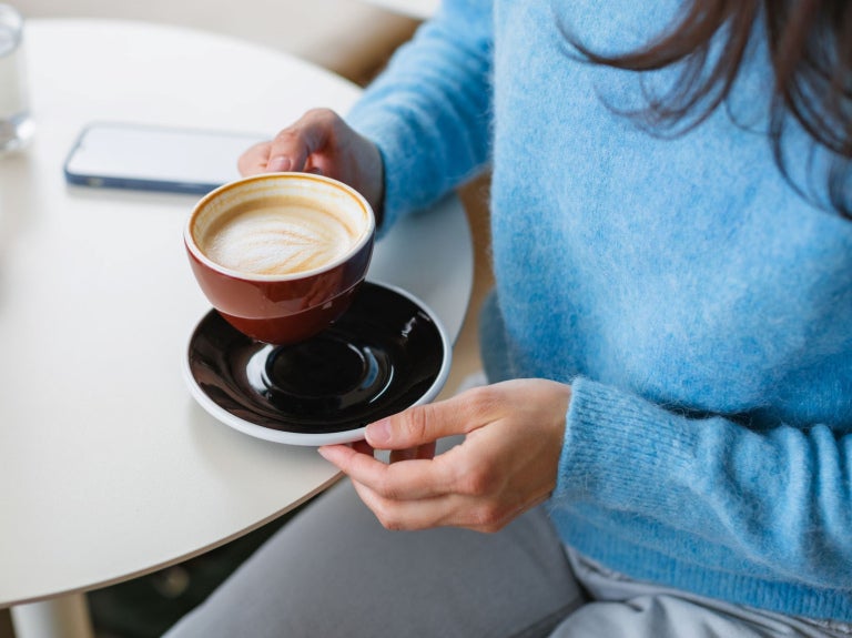 woman holding a flat white