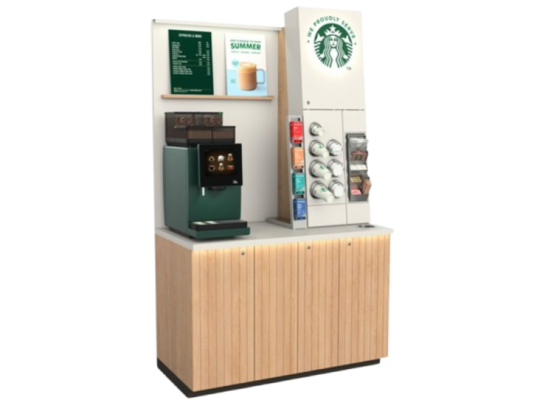 Starbucks self-serve coffee kiosk with espresso machine, syrup dispensers, cups, and promotional signage on a wooden cabinet