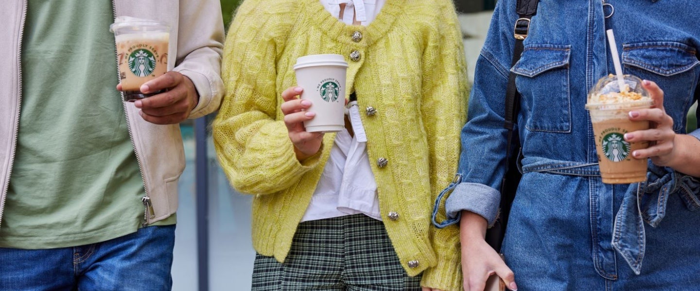 People carrying hot and iced Starbucks drinks