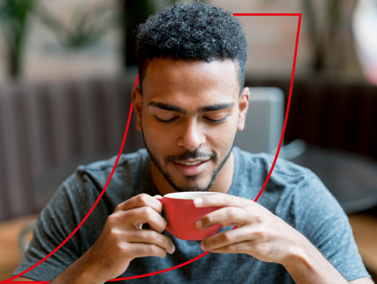 Male sitting enjoying a cup of Nescafé coffee