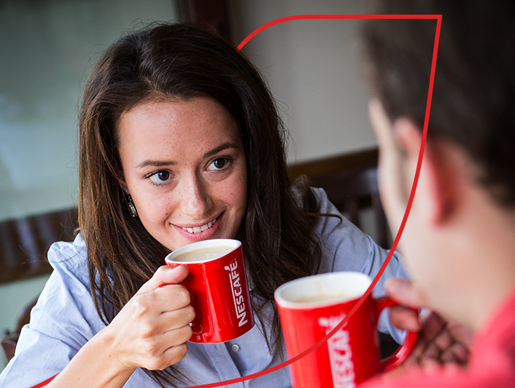 woman drinking coffee from NESCAFÉ mug