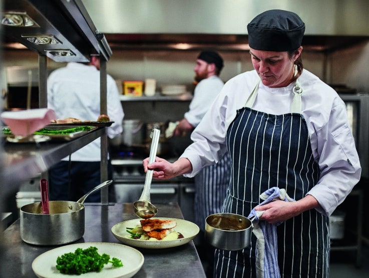 Chef plating food in kitchen