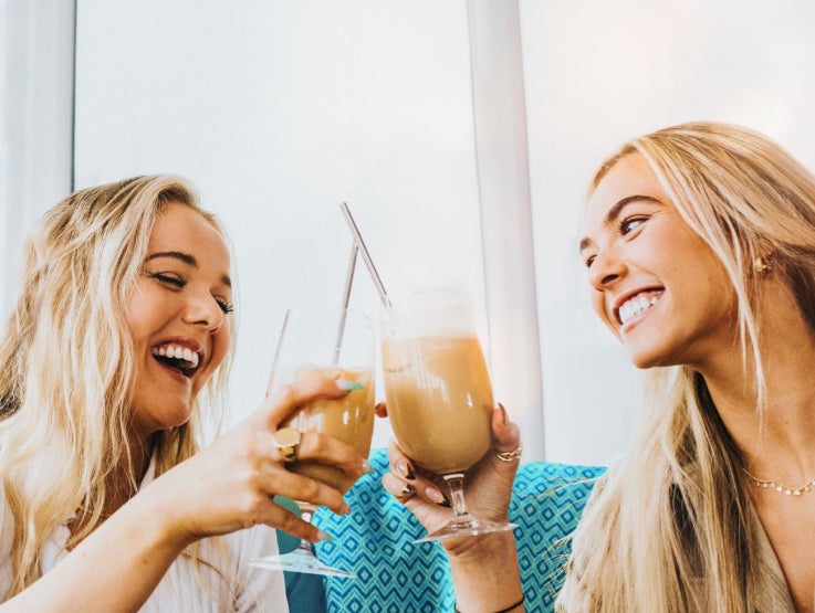 two women with iced lattes