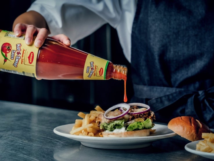maggi indian sauce being poured on burger