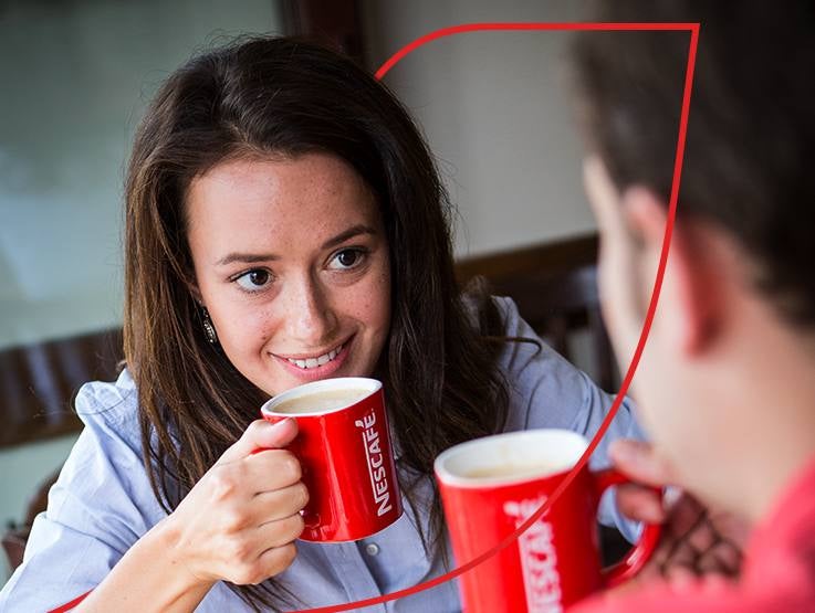 woman drinking coffee from NESCAFÉ mug