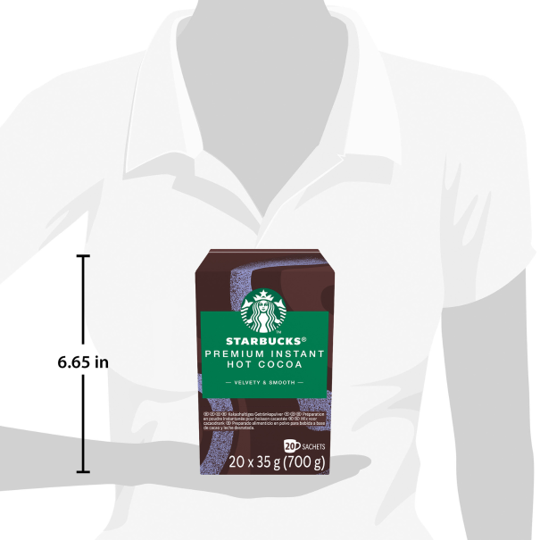 A person holding a Starbucks Premium Instant Hot Cocoa box with measurement markings, showcasing the packaging size