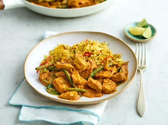 vegan curry served in a dish with slices of lemon