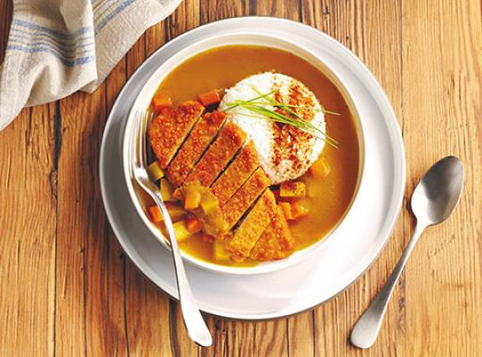 katsu curry dish with breaded fillet on a plate