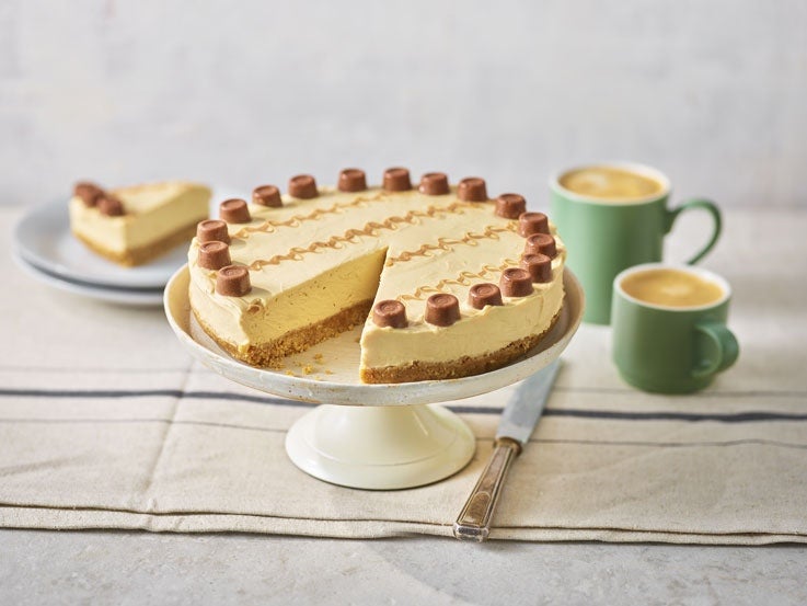millionaire cheesecake made with Rolo chocolate pieces and positioned on a cake stand