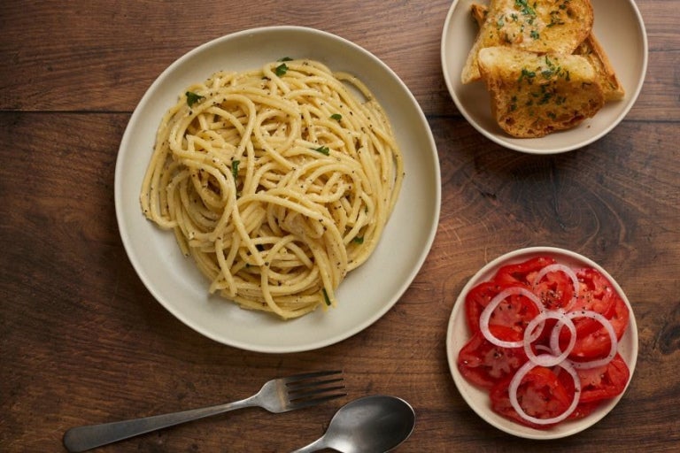 cacio e pepe truffle pasta dish plated with side salad