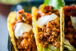 Quorn fruity chilli tacos topped with cheese, sour cream and lettuce