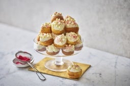 MILKYBAR White Chocolate and Raspberry Jam Profiterole Tower on a glass cake stand