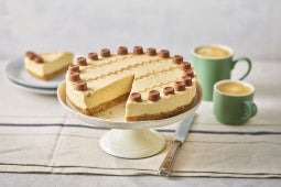 millionaire cheesecake made with Rolo chocolate pieces and positioned on a cake stand