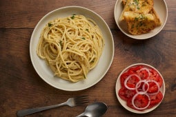 cacio e pepe truffle pasta dish plated with side salad