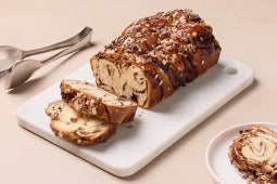 Sliced loaf with topping on board.