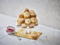 MILKYBAR White Chocolate and Raspberry Jam Profiterole Tower on a glass cake stand