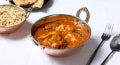madras fish curry dish plated served with rice and naan