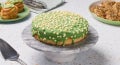 Green‑iced cake with white sprinkles.
