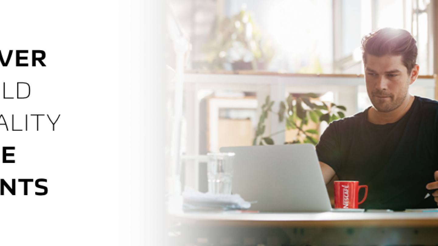 man working on his laptop with a cup of NESCAFE coffee