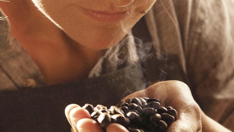 woman smelling roasted coffee beans